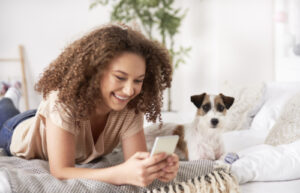 Teenage girl using mobile phone and lying on the bed