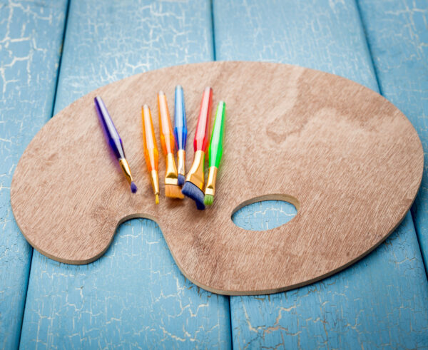 Wooden art palette with paint brushes