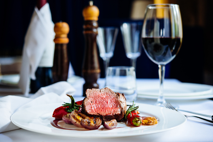 Beef steak with grilled vegetables served on white plate