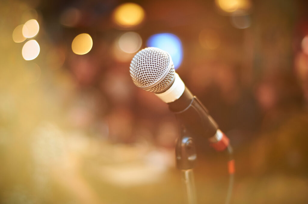 microphone in concert hall or conference room with warm lights in background