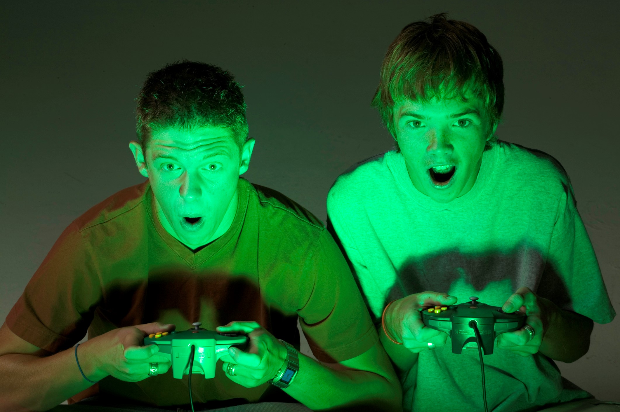 Two young men sitting playing video games